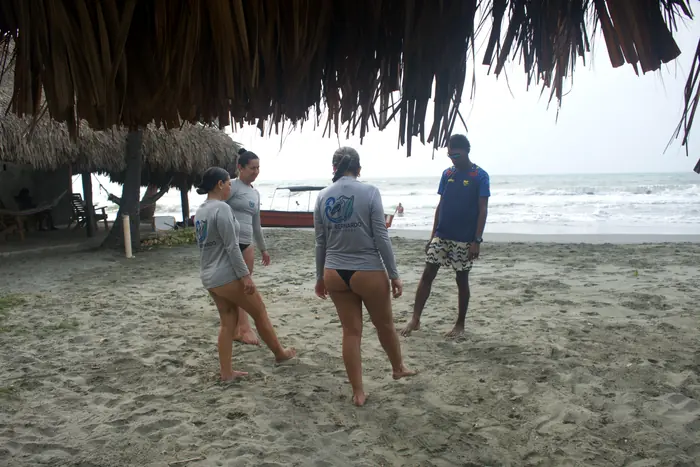 Instructor guiando el calentamiento en la playa