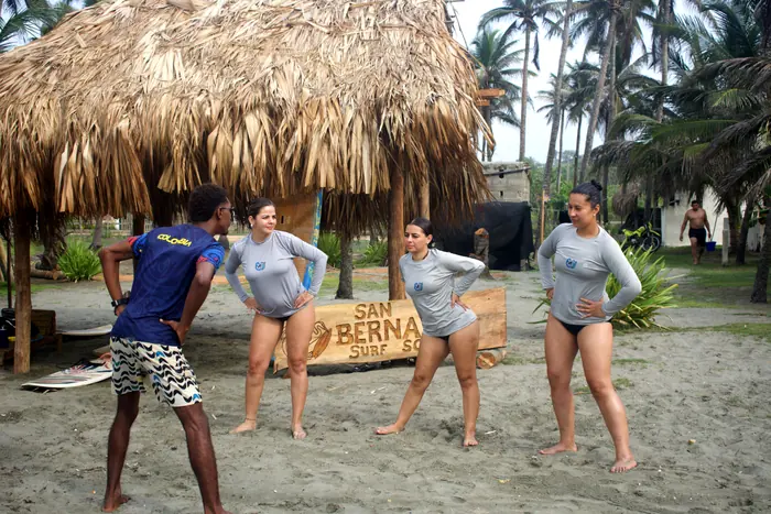 Instructor dirigiendo el calentamiento con alumnas junto al kiosco